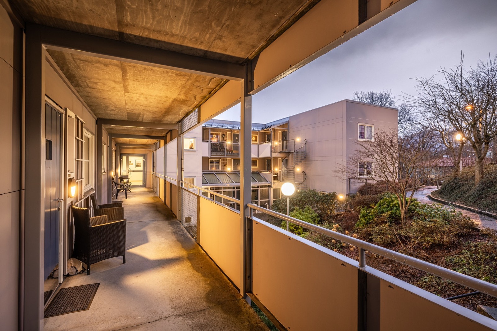 Utsikt mot stille bakhage ved inngangspartiet til leiligheten Galleribilde