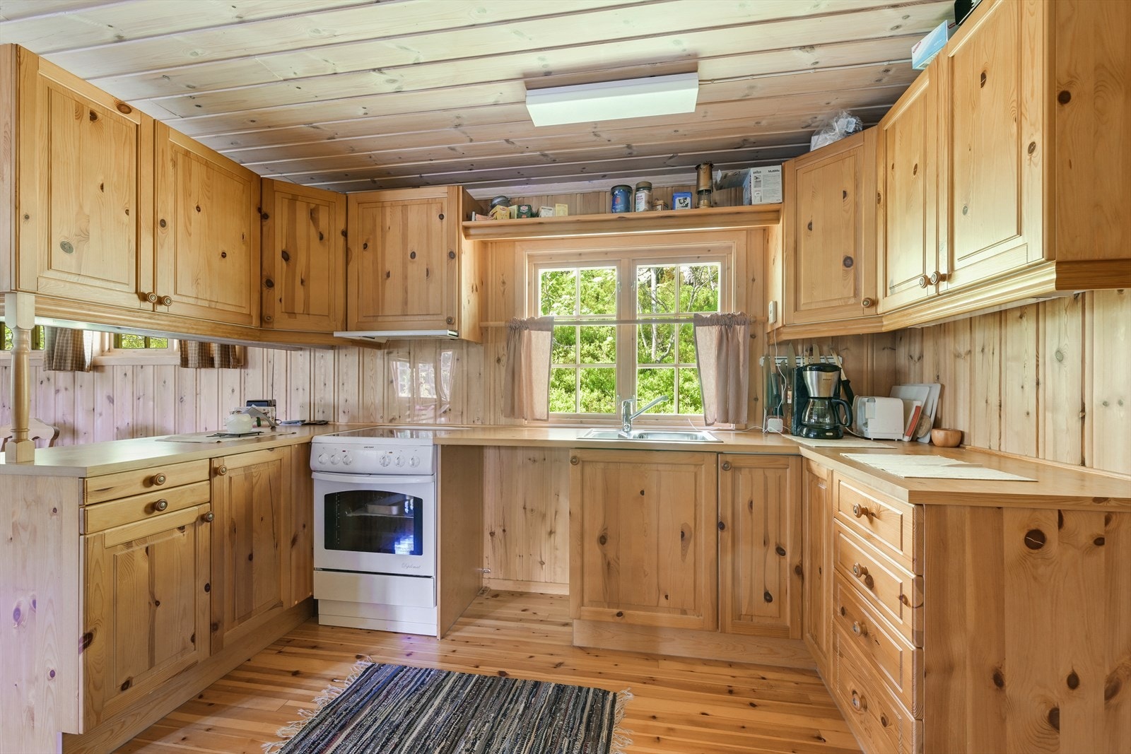 Velutstyrt kjøkken med heltre skrog og laminert benkeplate. Galleribilde