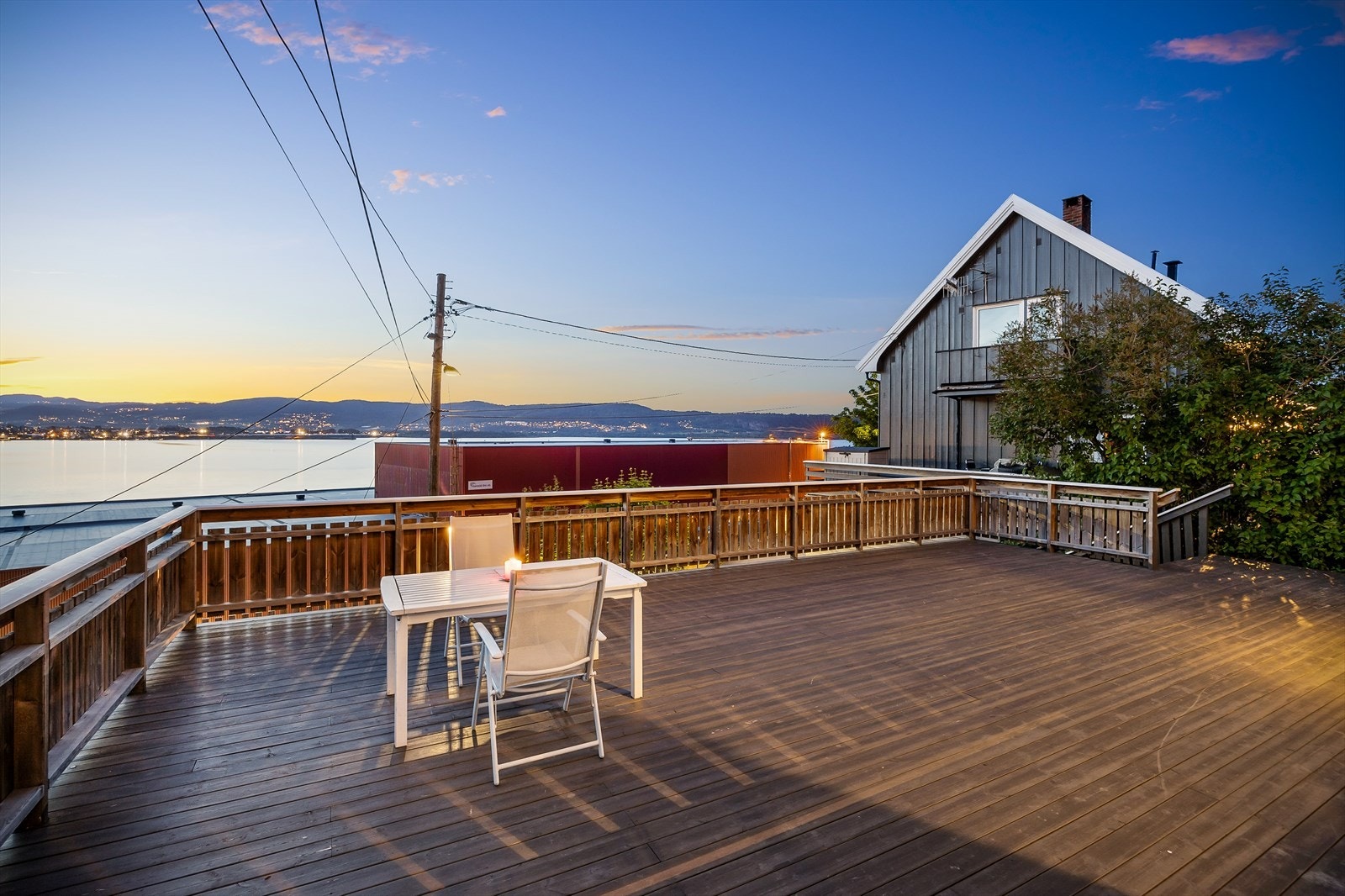 Romslig terrasse foran inngangspartiet til felles bruk for begge seksjonene i tomannsboligen - Her har man særdeles flotte utsiktsforhold. Det gjøres oppmerksom på at det på andre siden av veien for eiendommen nede ved fjorden skal bygges nye leiligheter Galleribilde