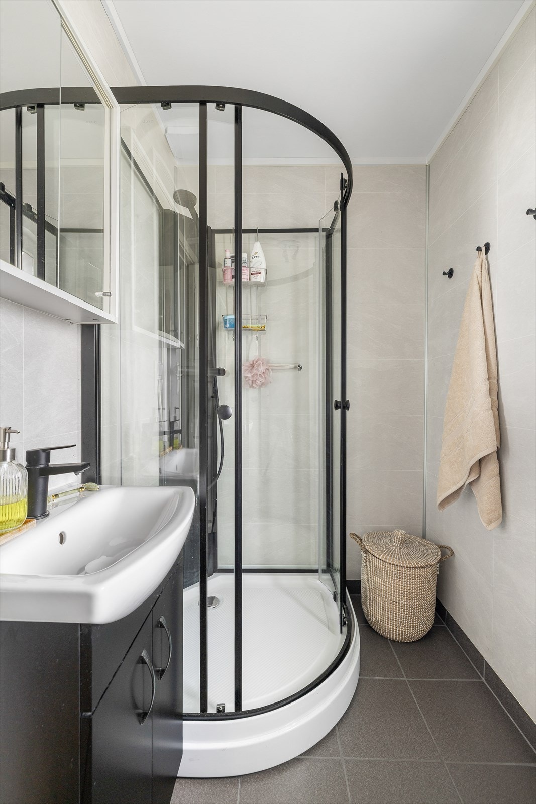 Badet i 1.etasje ble pusset opp i 2025 med nye varmekabler, ny servant og speilskap. Det er flislagt gulv med varmekabler, våtromsplater på veggene og malt tak. Badet er innredet med dusjkabinett og innredning med nedfelt servant Galleribilde