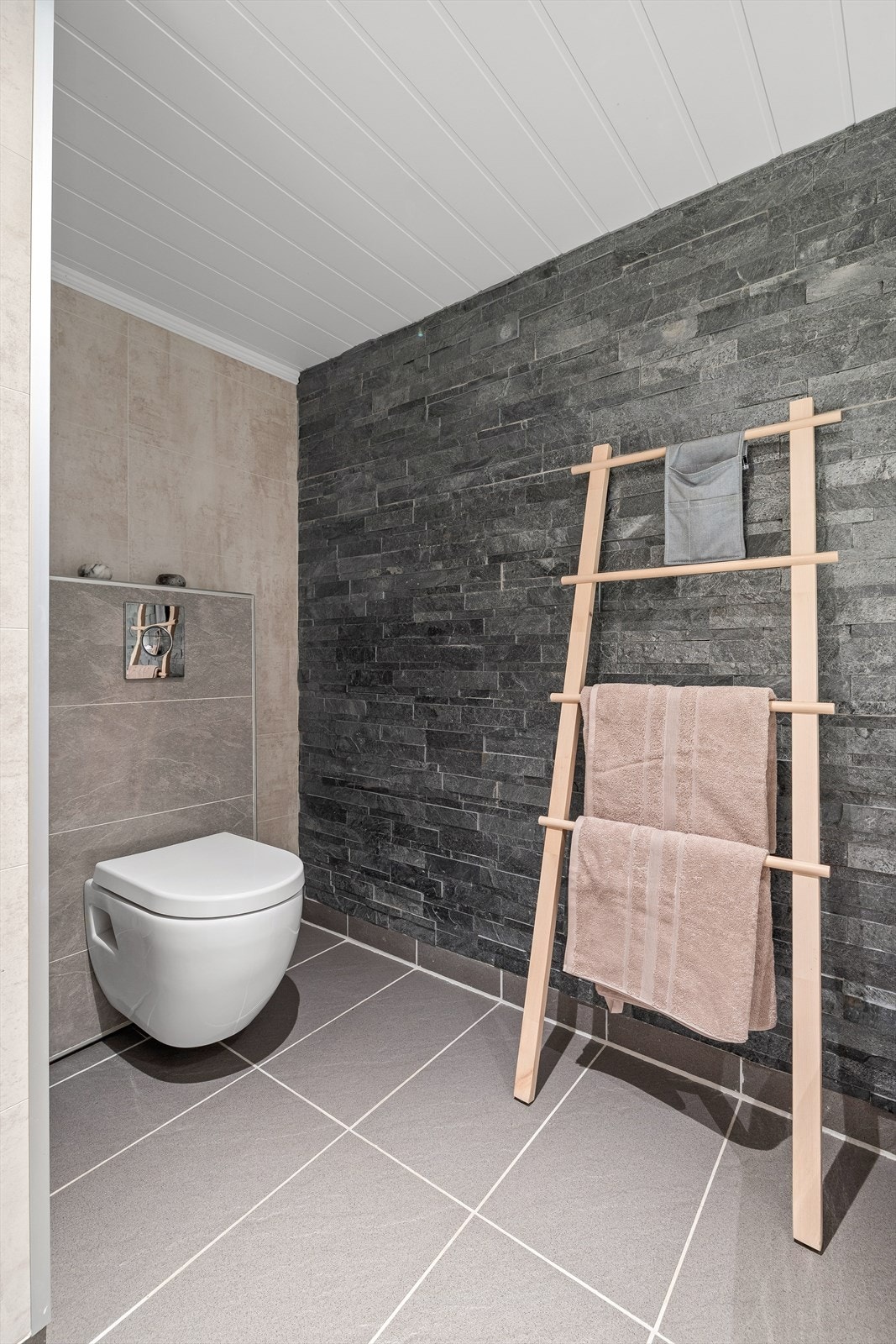 Det er baderomsplater/skiferbelagt på veggene, malt MDF-plater i taket og flislagt gulv med varmekabler Galleribilde