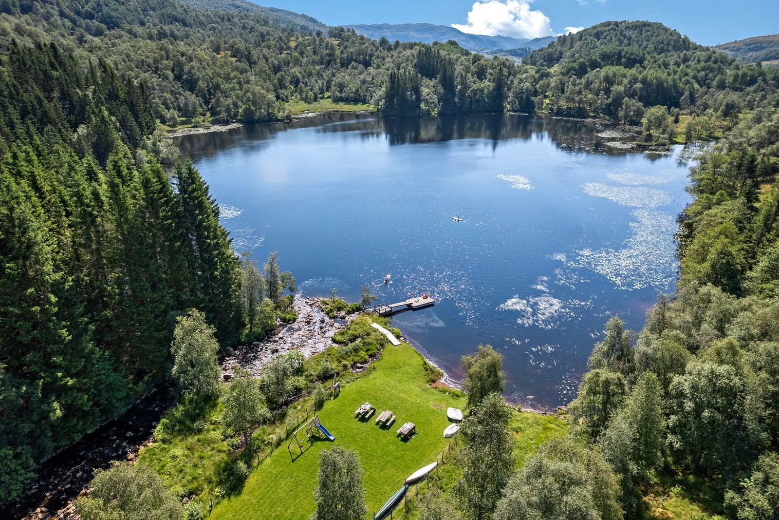 Hyttefeltet har et flott fellesområde ved vannet. Her kan du grille, bade og tilbringe kvalitetstid med familie venner og naboer, mens barna kan leke i trygge omgivelser. Galleribilde