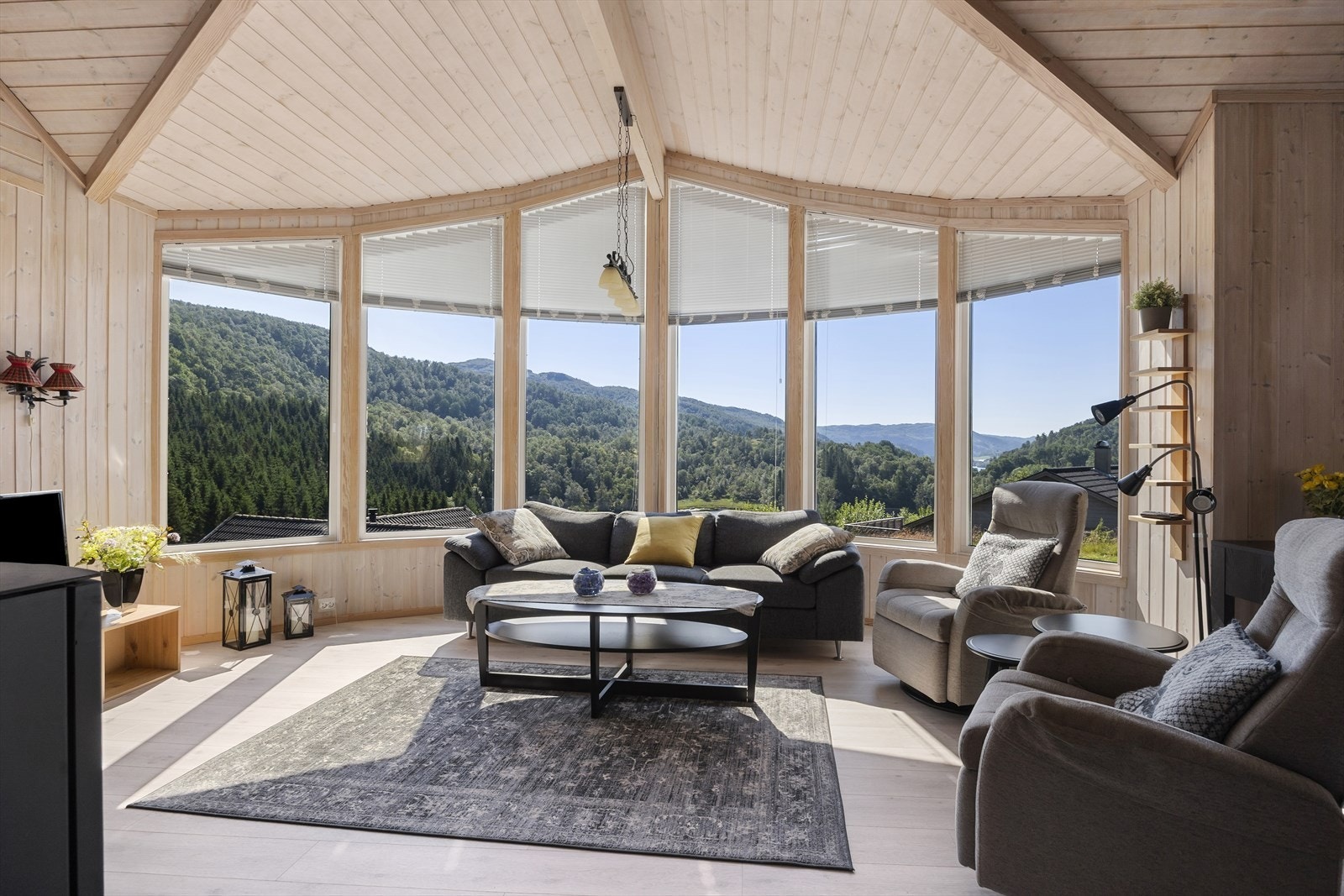 Stue med store vindusflater i front gir rikelig med lys og en spektakulær utsikt over fjell og hei. Galleribilde