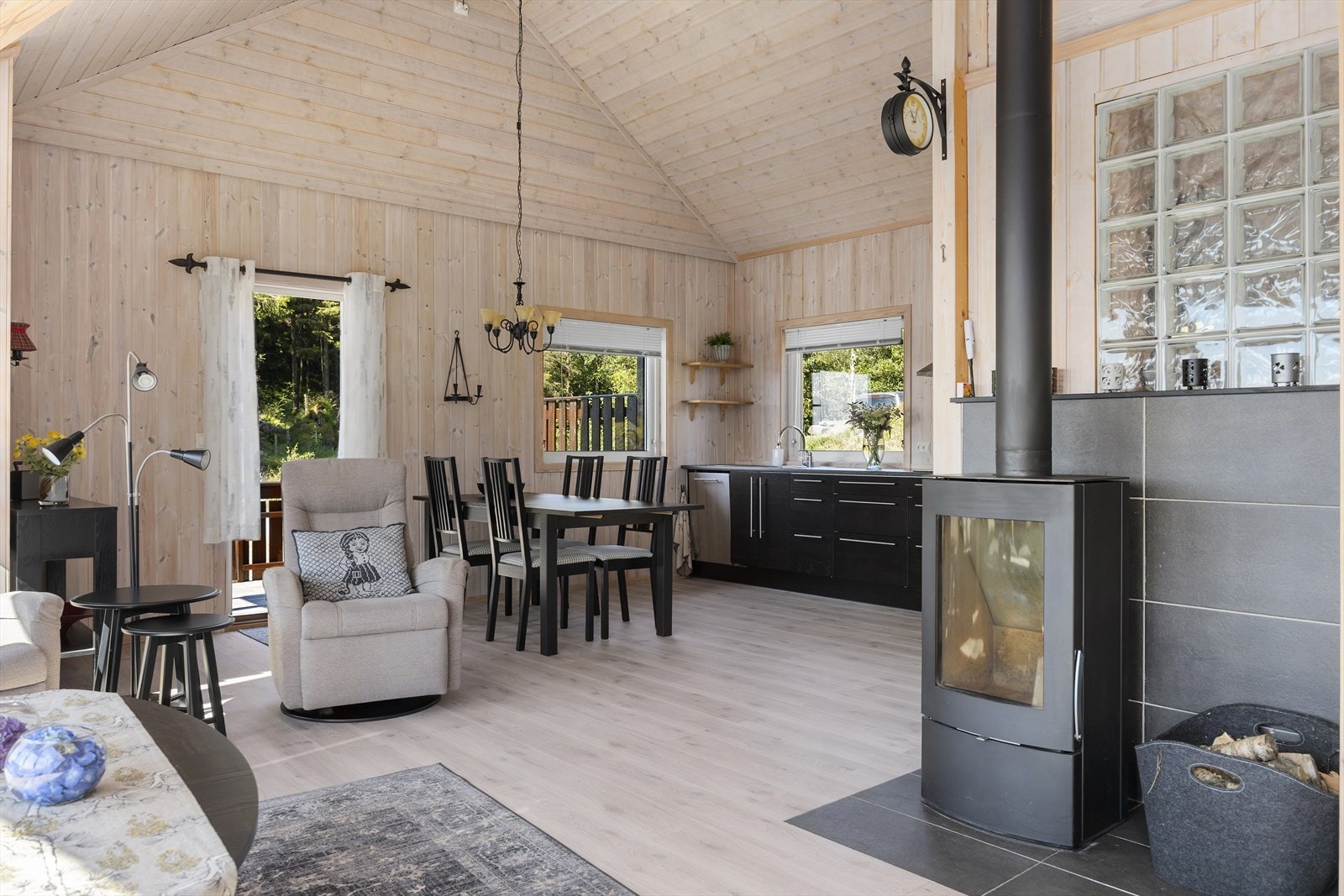 Stuen og kjøkkenet ligger i en åpen løsning som skaper et sosialt og naturlig samlingspunkt. Vedovn tilfører lun varme og hygge på kjølige dager, Galleribilde