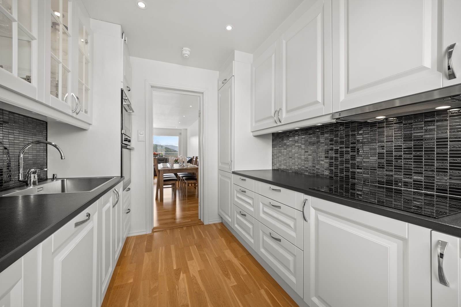 Kjøkkenet har profilerte fronter og integrerte hvitevarer Galleribilde