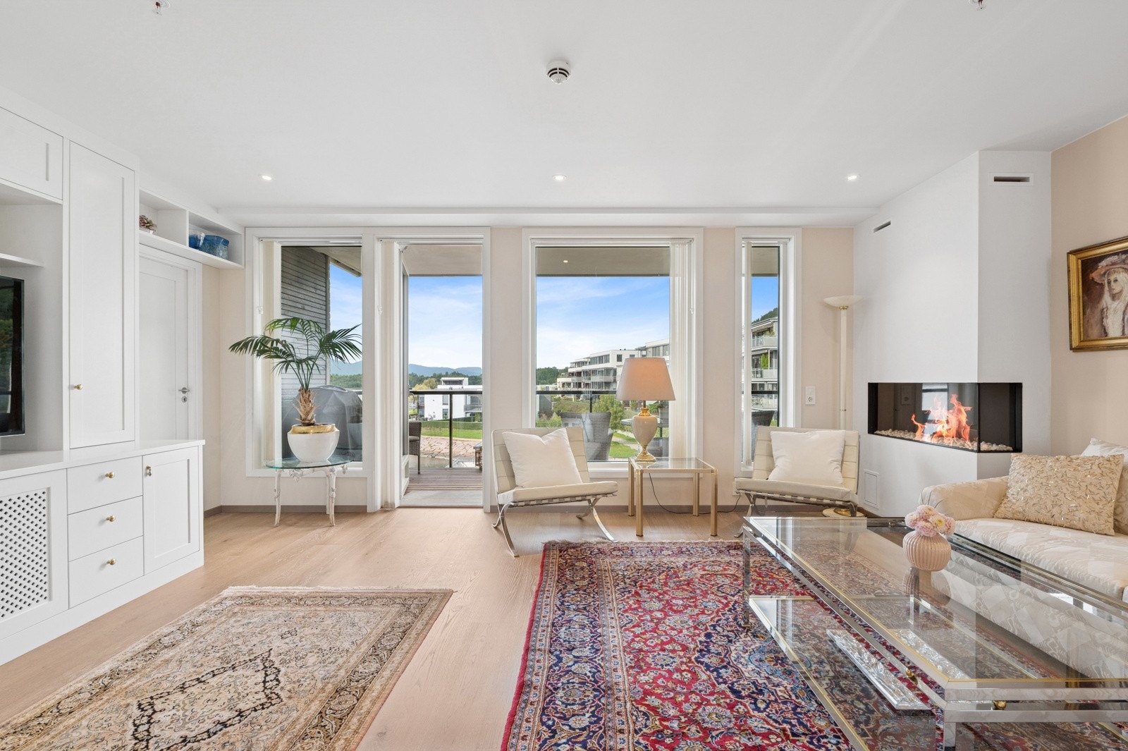 Romslig og lys stue med stilren gasspeis og store vindusflater med utsikt mot fjorden. Galleribilde