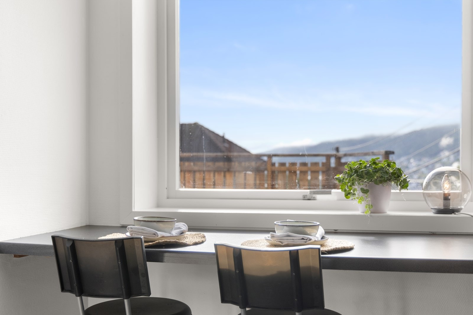Det er etablert en spiseplass med barstoler langs benk foran vindu Galleribilde