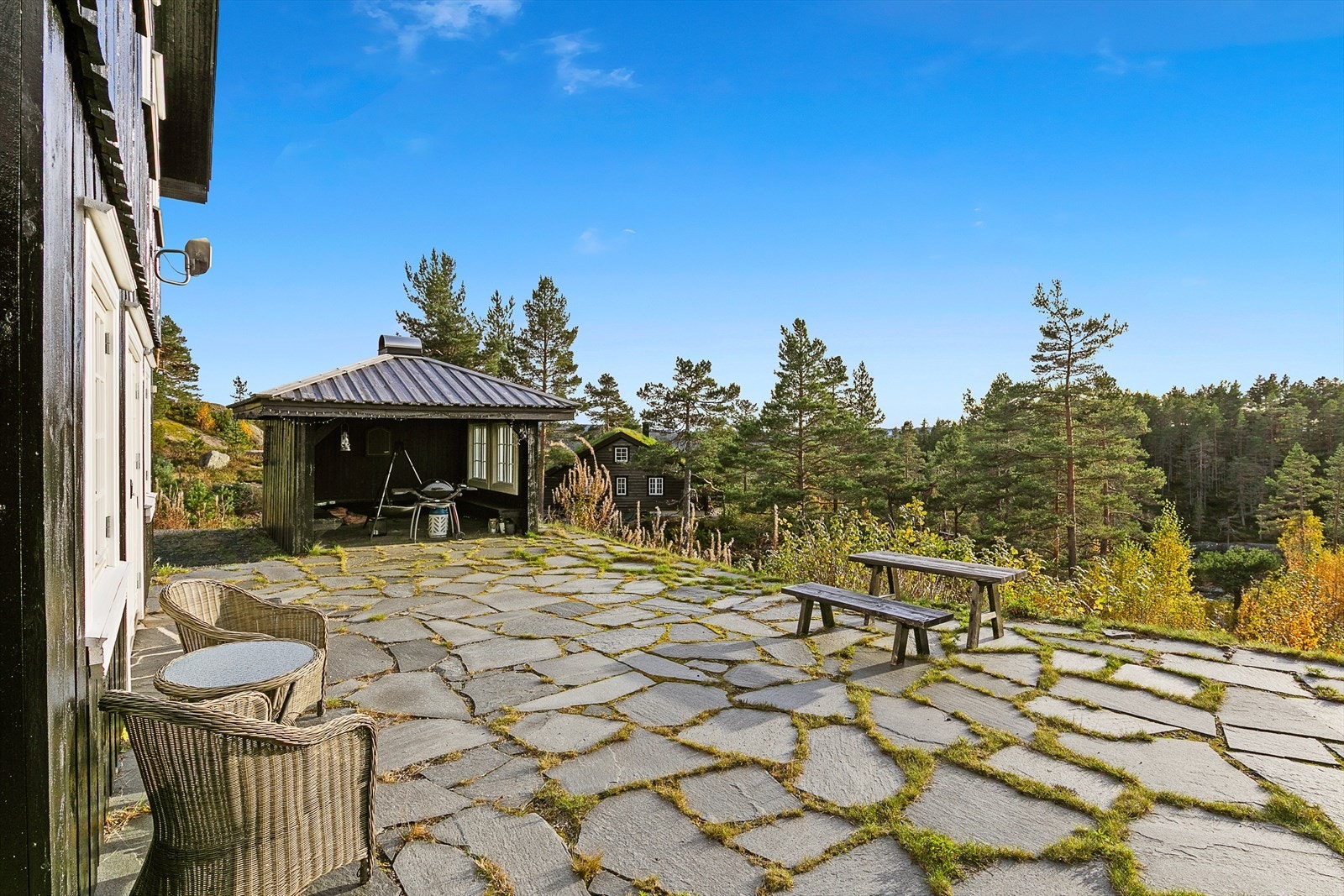 Uteplassen ligger usjenert til og er anlagt med flotte skiferheller, i direkte tilknytning til inngangspartiet og begge stuene. Galleribilde