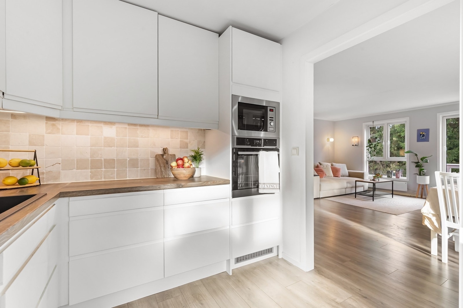 Kjøkkenet har slette fronter på skap og skuffer, benkeplate av laminat med nedfelt oppvaskkum, integrert platetopp, stekeovn, mikrobølgeovn, kjøleskap og oppvaskmaskin Galleribilde