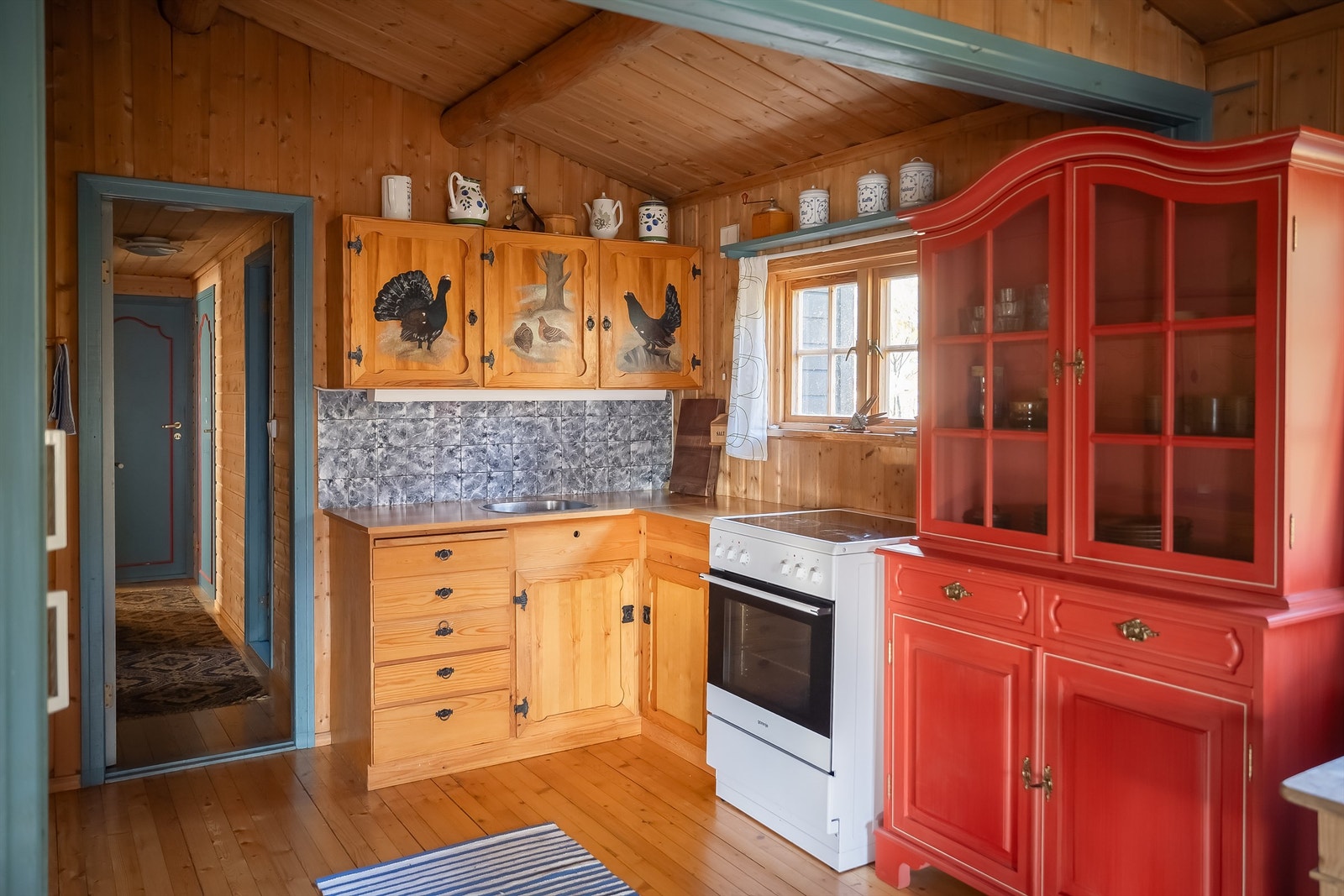 Kjøkkenet ligger naturlig tilbaketrukket fra stuen og har heltre innredning, frittstående komfyr og kjøleskap med fryser. Galleribilde