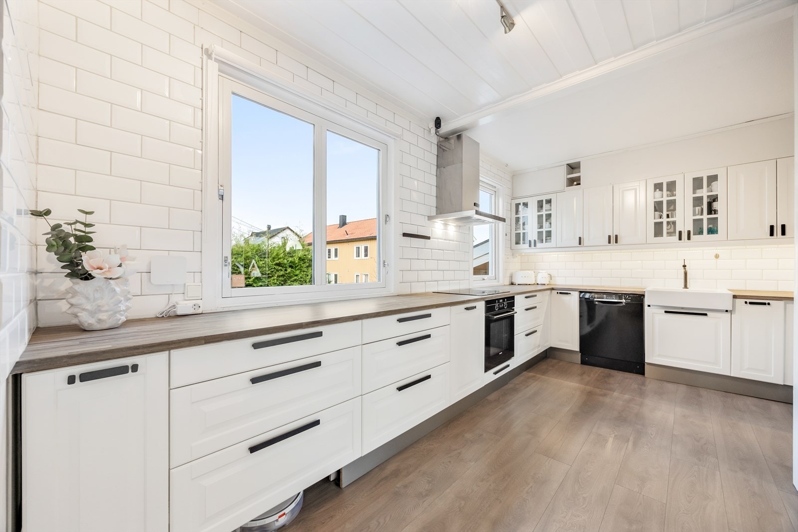 Innredningen har hvite profilerte fronter, vitrineskap og laminerte benkeplater Galleribilde