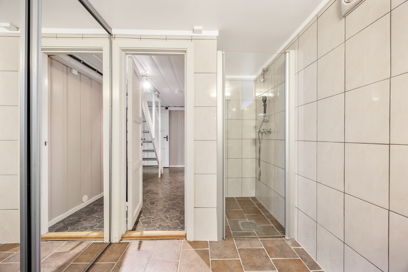 I tillegg er det opplegg og plass til vaskemaskin bak skyvedører med speilflater Galleribilde