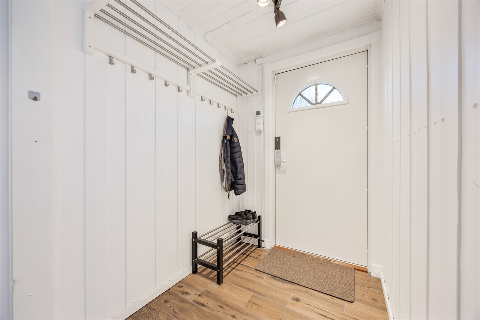 Innenfor døren med kodelås kommer du inn i en praktisk og innbydende entré med varme i gulvet Galleribilde