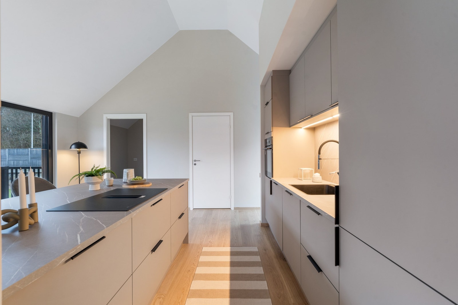 Kjøkken mot skyvedør til spisskammer (åpen) og inn til fløy med garderoberom, hovedsoverom og stort bad. Galleribilde