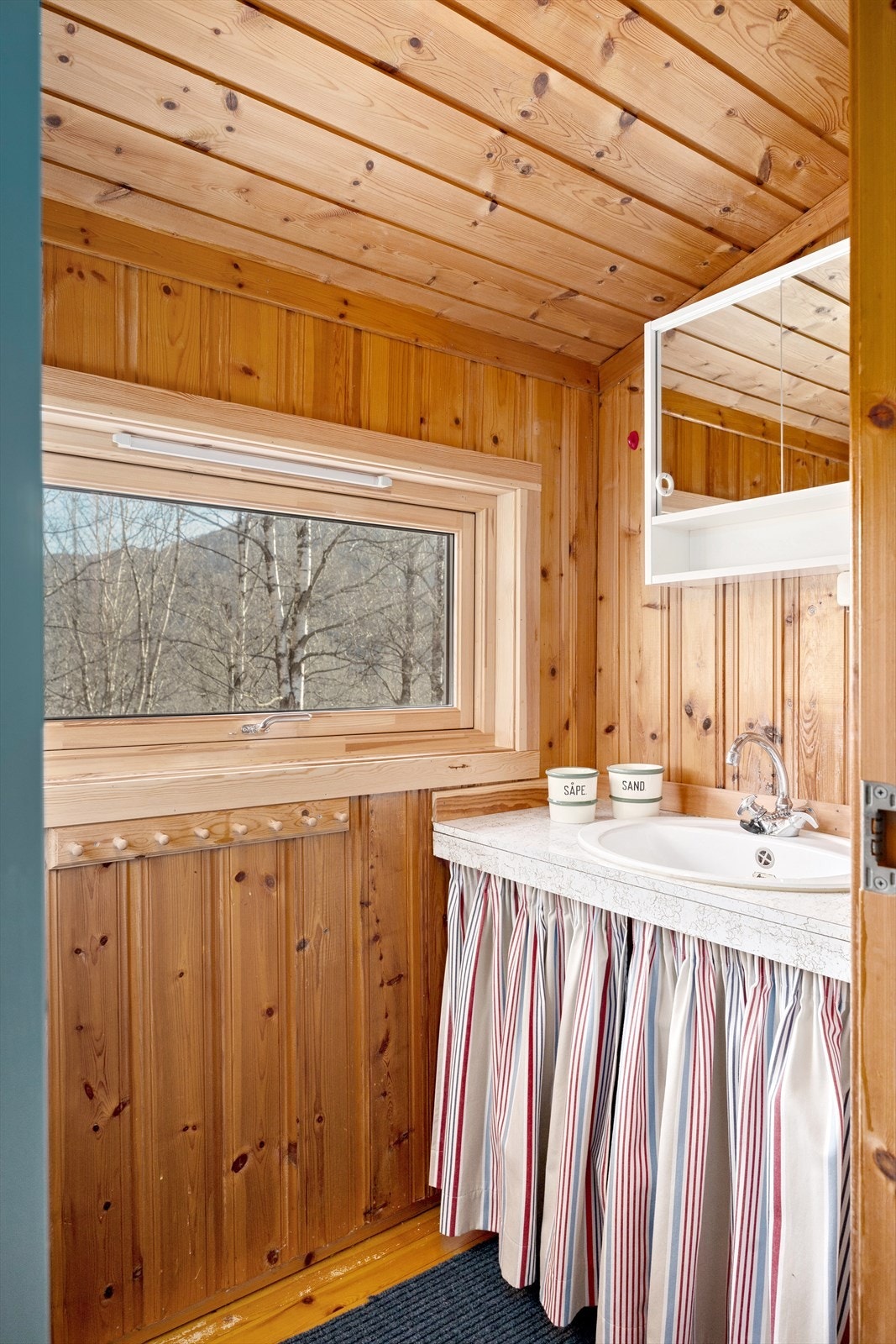 Bod som er innredet med servant og speilskap. Galleribilde