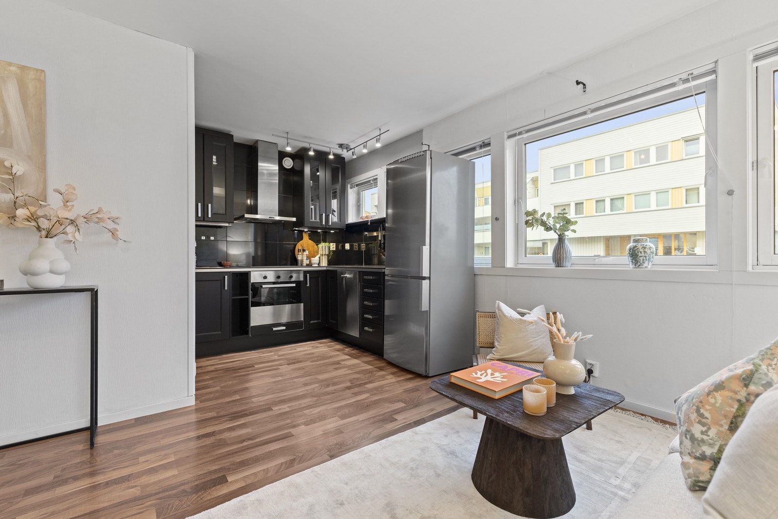 Kjøkkenet er holdt i en åpen løsning mot stuen, som skaper et sosialt samlingspunkt i leiligheten Galleribilde