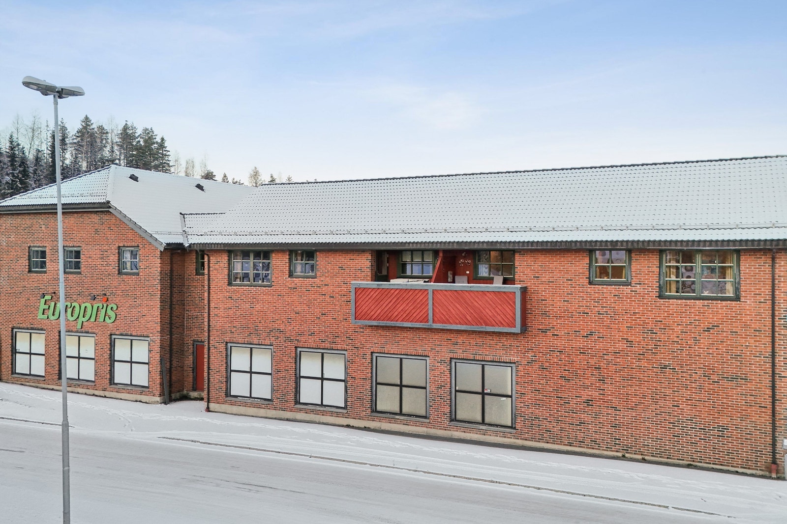 Byggets fasade er kledd med teglstein og stående trepanel. Galleribilde