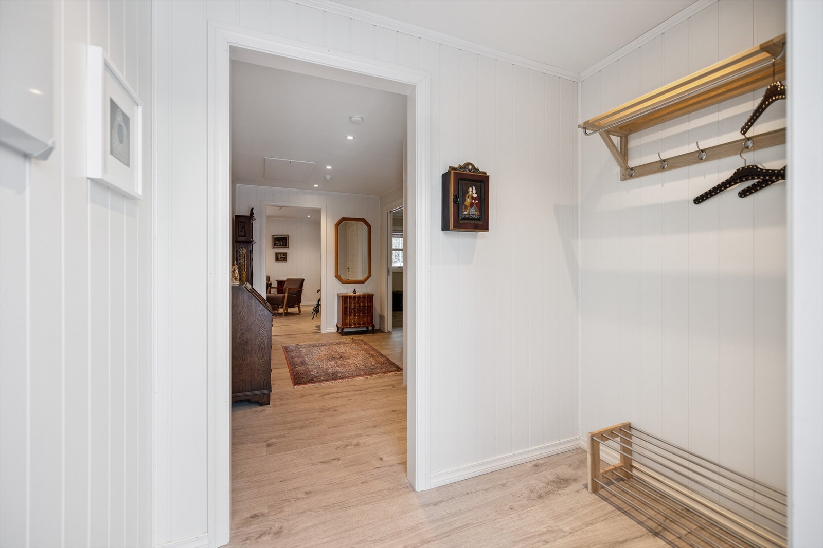Velkommen inn i en lys entré med plass til å henge fra seg yttertøy. Galleribilde