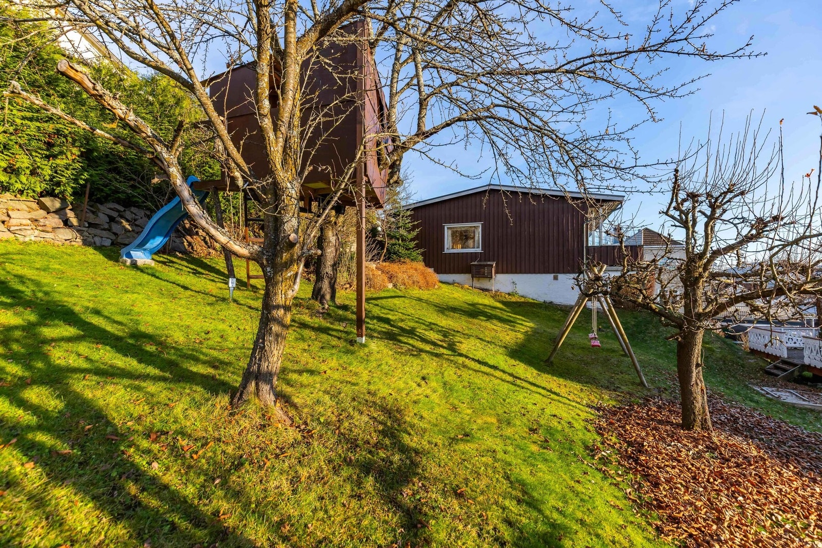 Det er romslig hage, som er opparbeidet med lekeapparater. Disse tilhører naboen og kan fjernes om ønskelig. Galleribilde