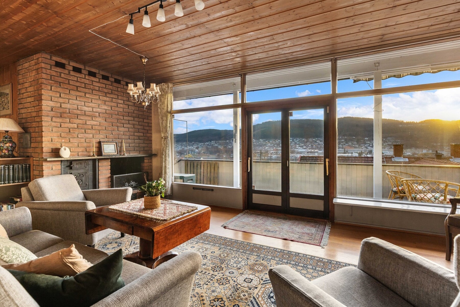 Stuen har god utsikt, peis med murvegg, store vinduer og en utgang til balkong. Galleribilde