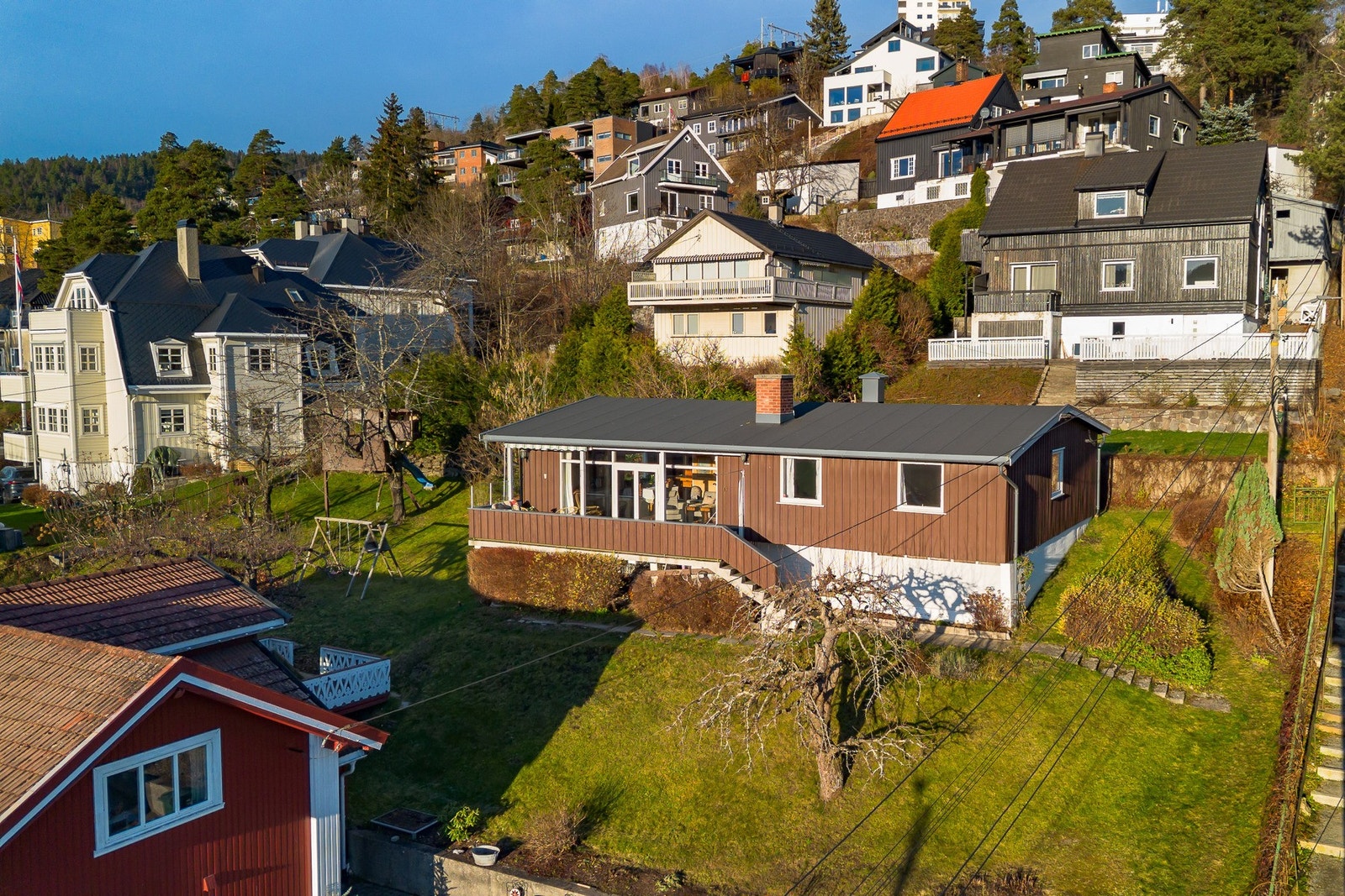 Boligen har en stor hage, ligger i et skrått terreng og har gode solforhold og utsikt Galleribilde