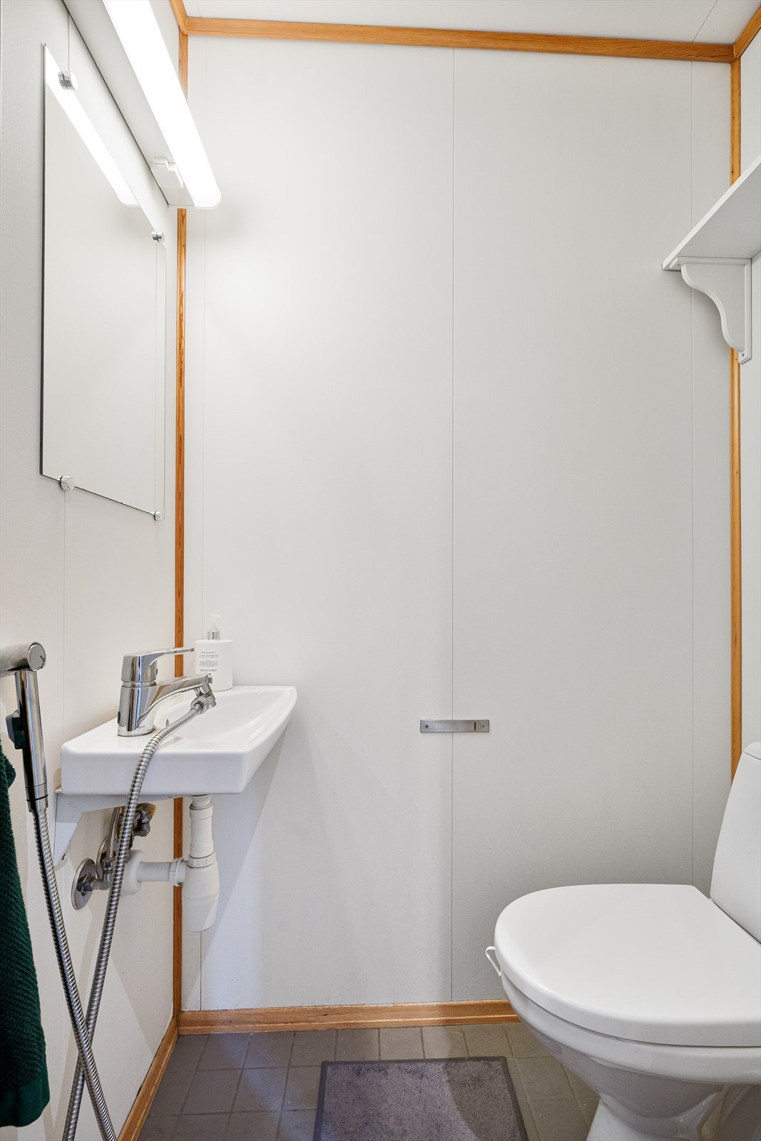 Lyst og praktisk gjestetoalett ved inngangen, med flislagt gulv og varmekabler. Galleribilde