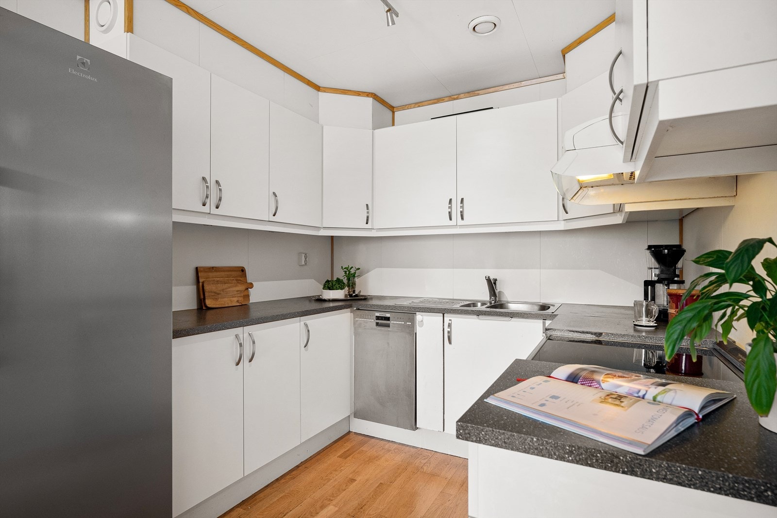 Kjøkkeninnredning med lyse glatte fronter og god skap- og benkeplass. Galleribilde