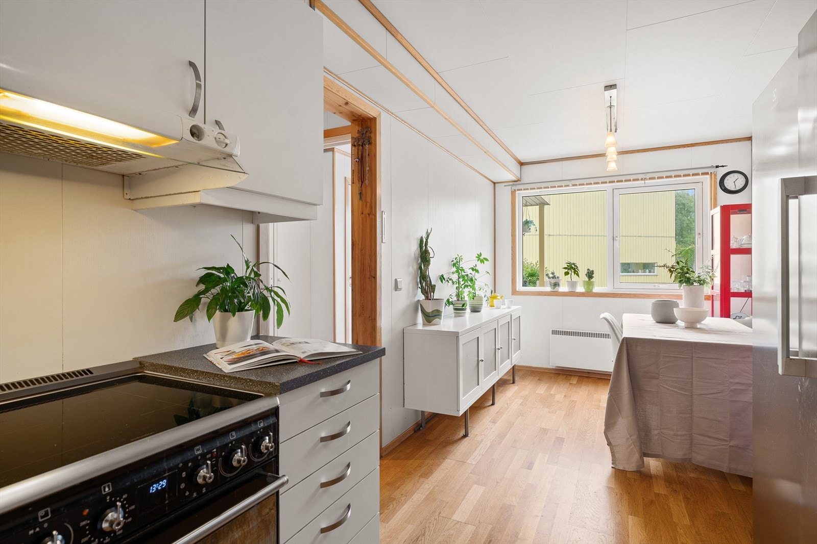 Det separate kjøkkenet gir et avgrenset og funksjonelt rom, med spiseplass plassert ved vinduet for ekstra lys og utsyn. Galleribilde