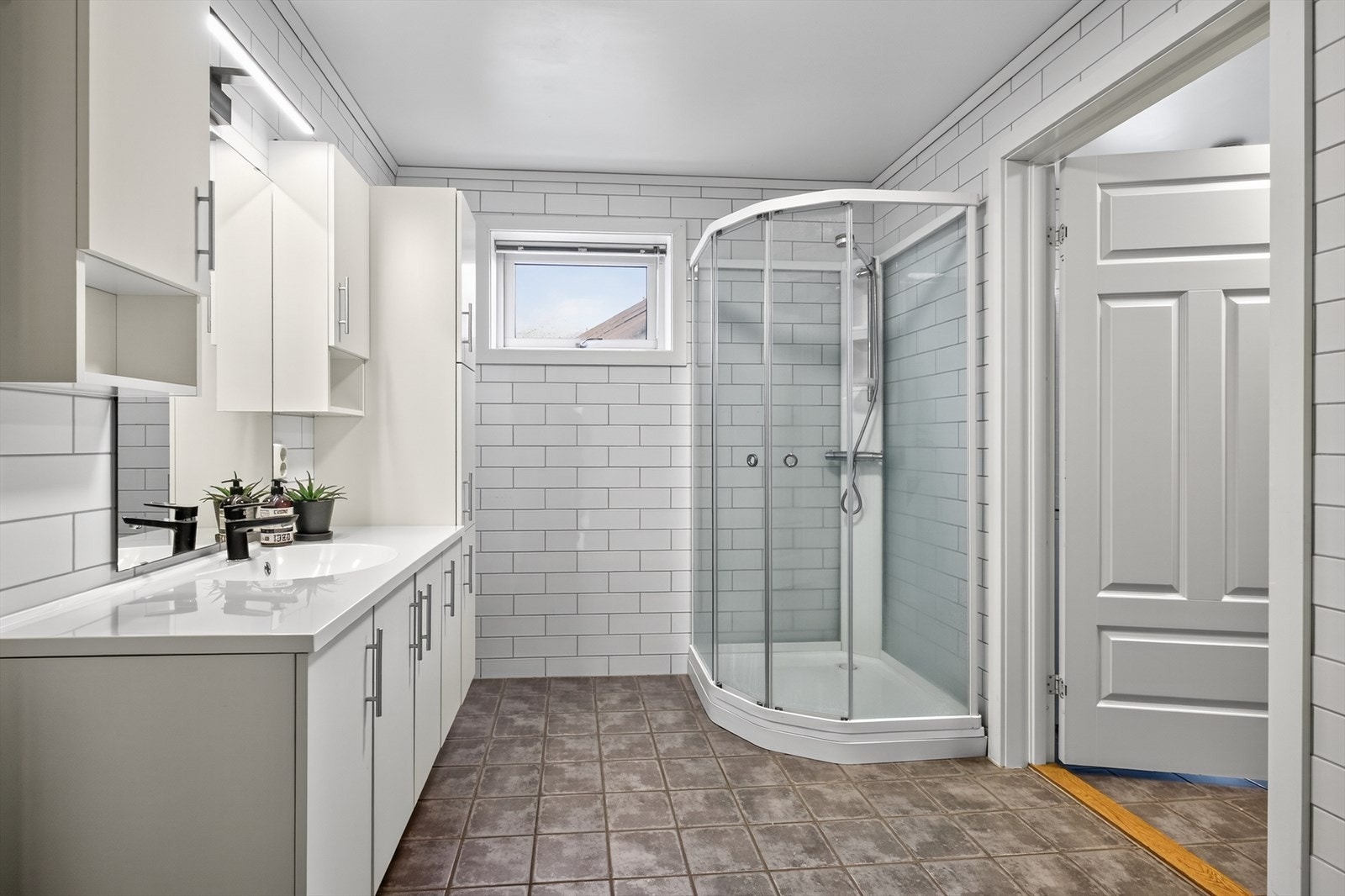 Badet i hovedetasjen er helfliset med varmekabler i gulvet. Det flotte badet har en romslig baderomsinnredning med god skapplass og nedfelt servant, samt speil på vegg med overlys. Galleribilde