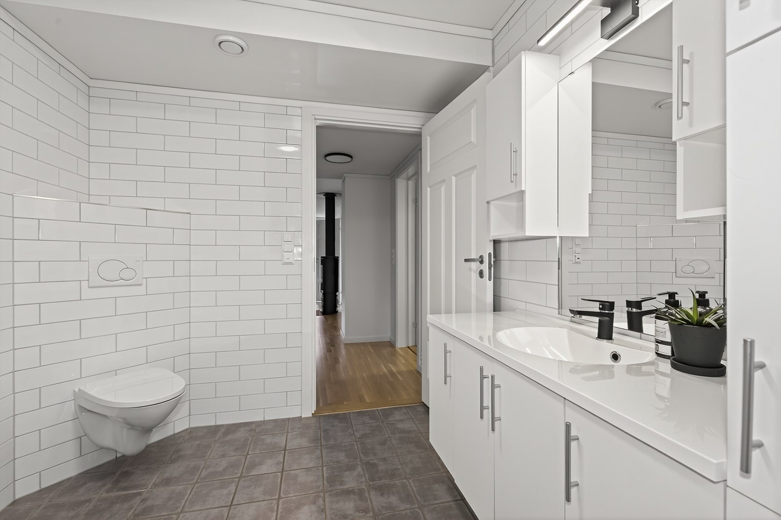 Badet er også innredet med dusjkabinett og veggmontert toalett. Selger opplyser at dusjkabinett og blandebatteri er nytt i 2025. Galleribilde