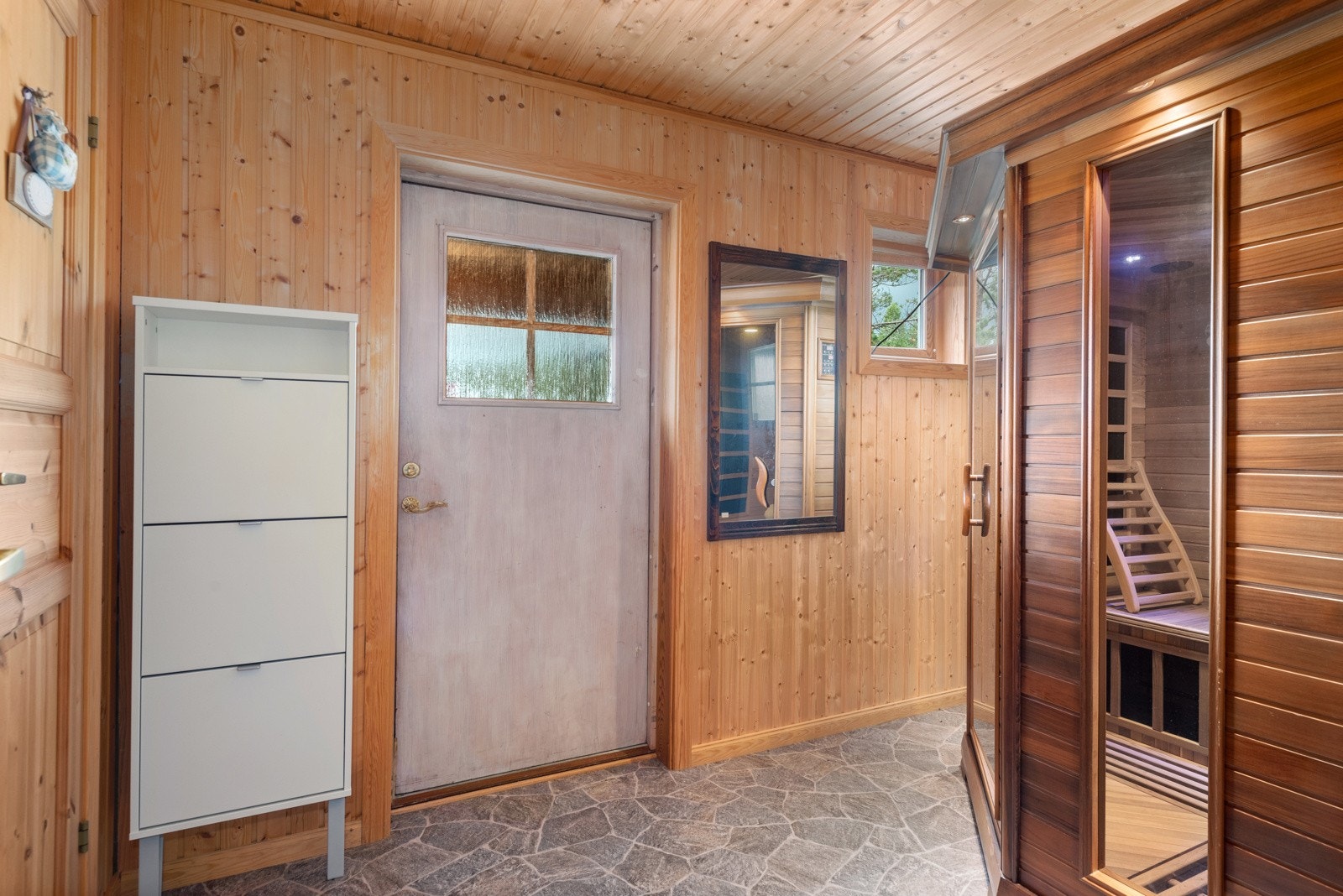 Stor og romslig entré med plass til å sette fra seg yttersko og henge fra seg yttertøy. Galleribilde