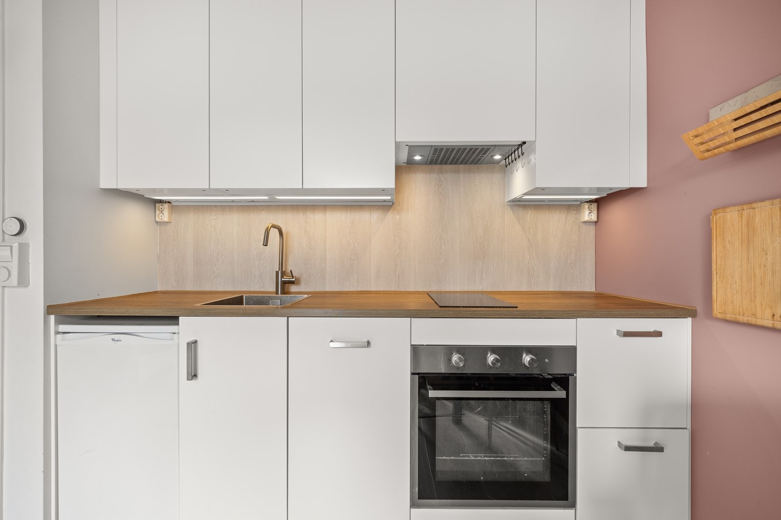 Kjøkkenet er utstyrt med integrert komfyr, platetopp og oppvaskmaskin Galleribilde