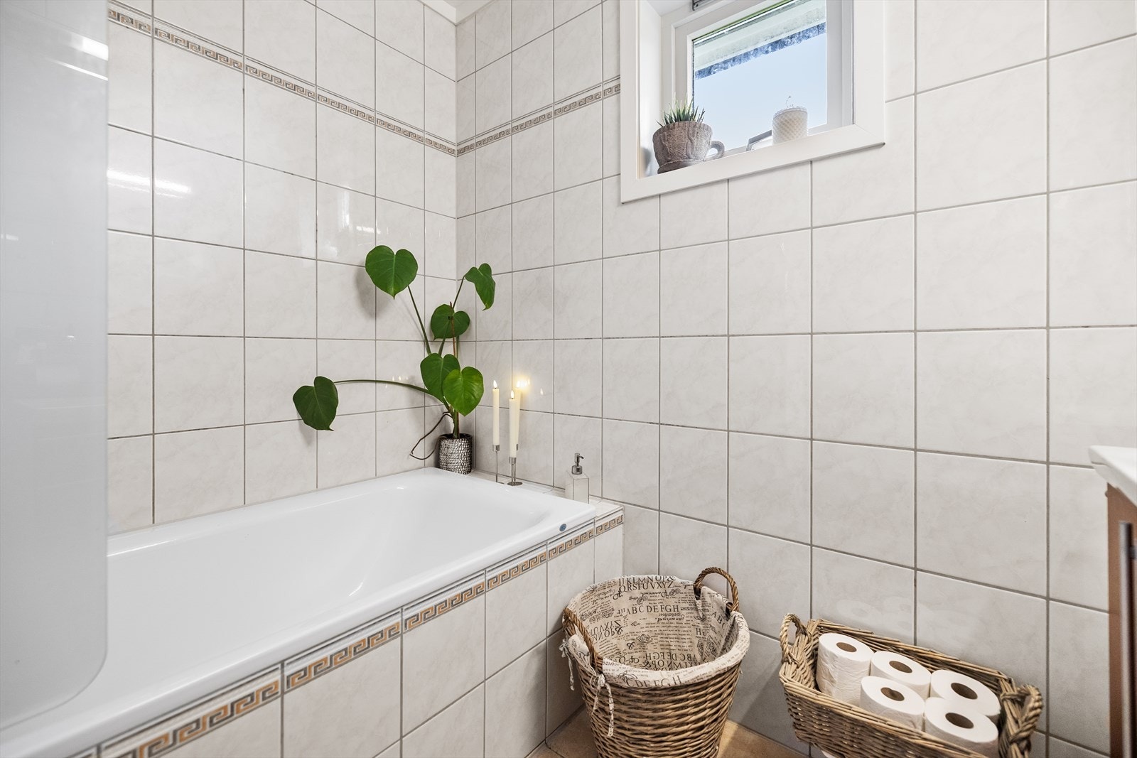 Rommet er innredet med servant, speil, toalett (nytt i 2025) og et plassbygd badekar med fliser, som gir rommet et klassisk og behagelig preg. Galleribilde
