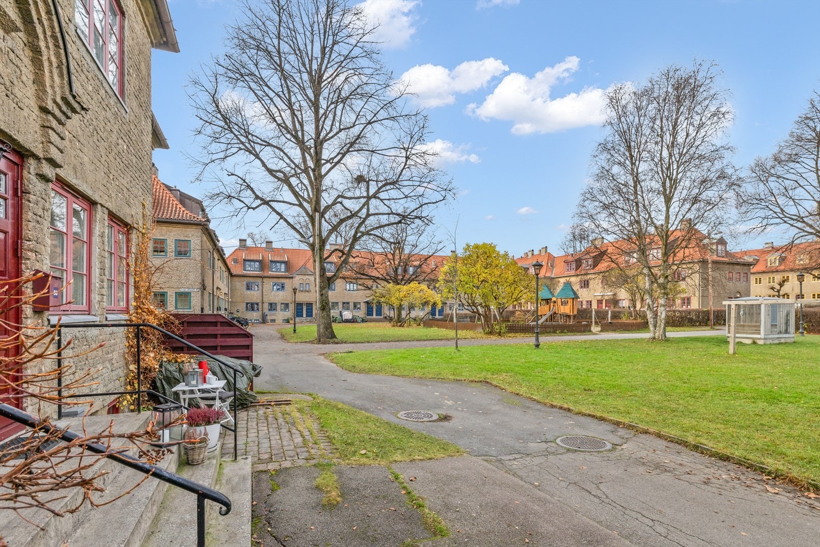 Uteplassen ved inngangspartiet har en helt egen kvalitet - et lunt og velkomponert. Dette er ikke en del av hagen, møblene står på borettslagets fellesareal. Galleribilde