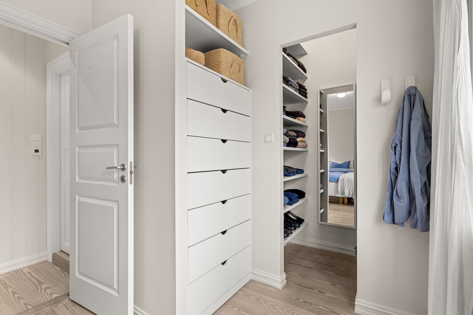 Praktisk og romslig garderobeløsning med god oppbevaringskapasitet. Her får du både åpne hyllesystemer og integrerte skuffer som gjør det enkelt å holde orden og ha full oversikt over klær og tilbehør. Galleribilde