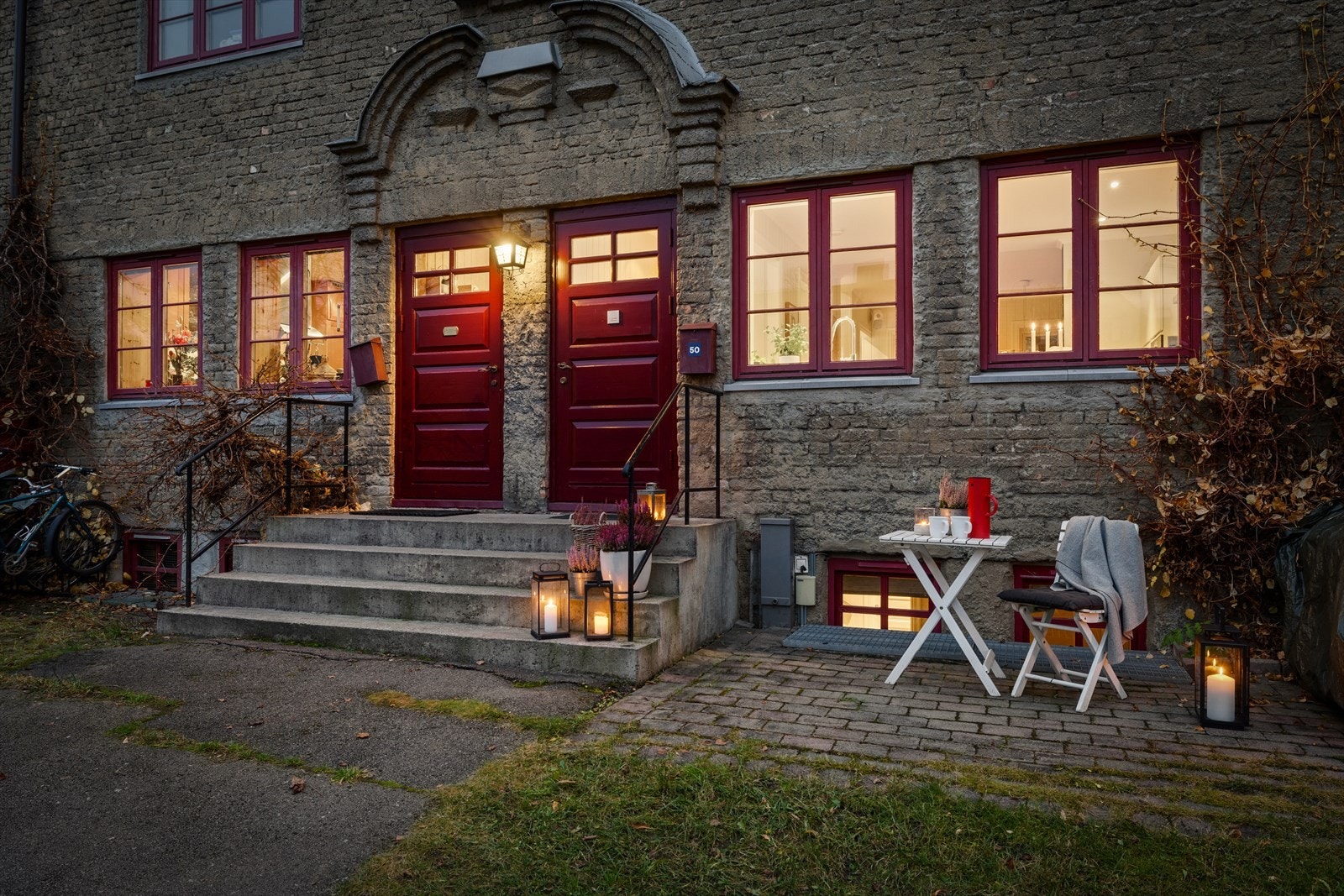 Inngangspartiet oppleves både praktisk og sjarmerende - et lite uterom som binder boligen sammen med hagebymiljøet rundt. Galleribilde