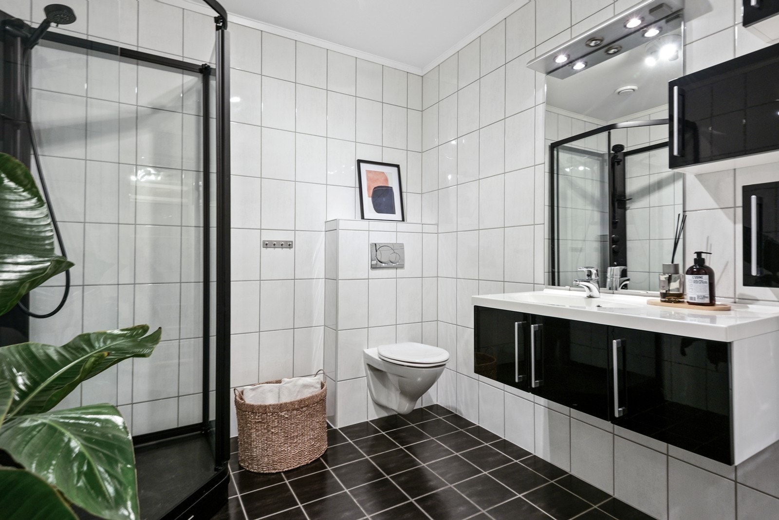 Badet i denne etasjen har flislagte overflater og gulvvarme. Her finner du vegghengt toalett, dusjkabinett og bred servant med underskap i høyglans. Galleribilde