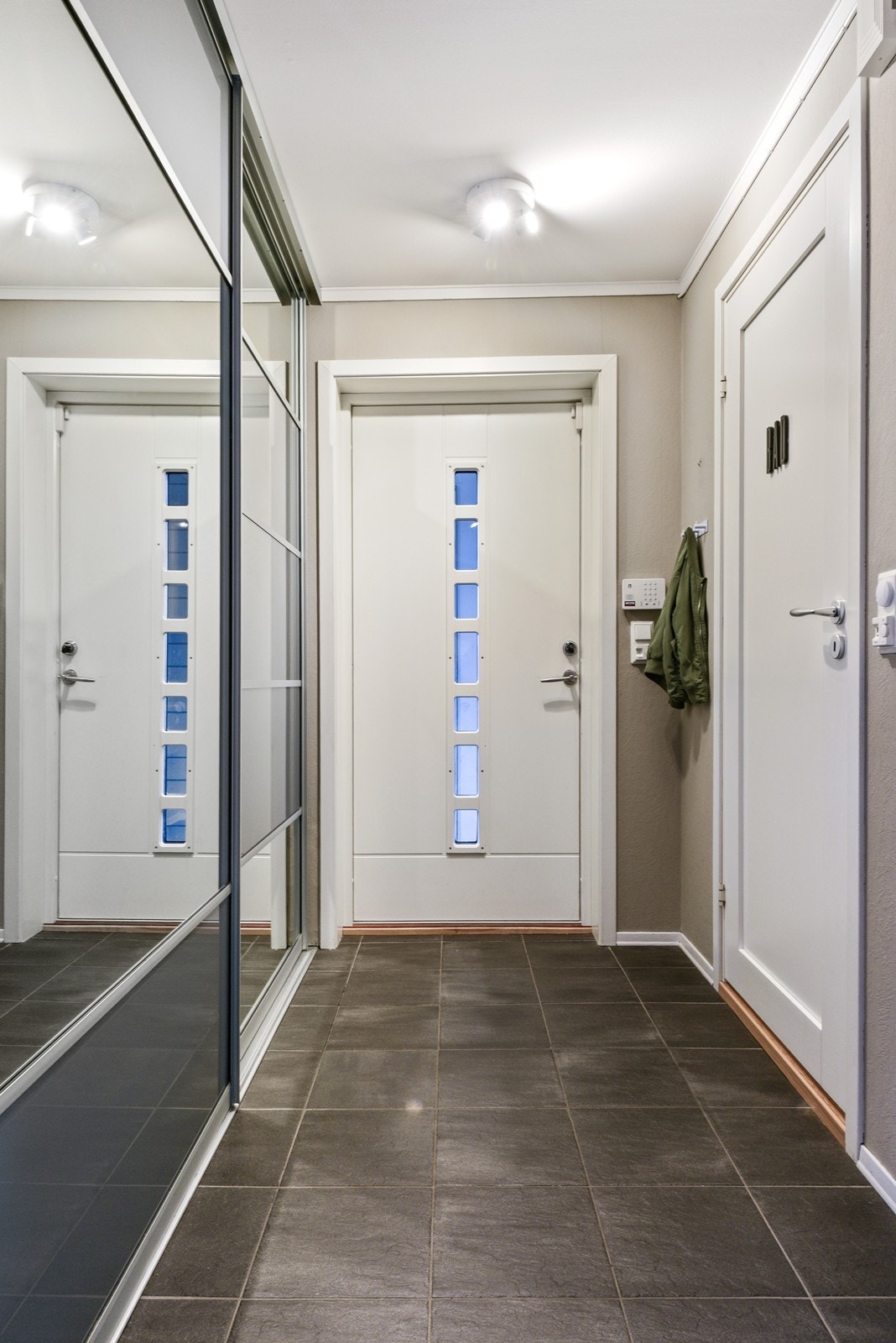 Stor skyvedørsgarderobe gir god oppbevaringsplass. Rett ved inngangen ligger ett av boligens to bad lett tilgjengelig. Galleribilde