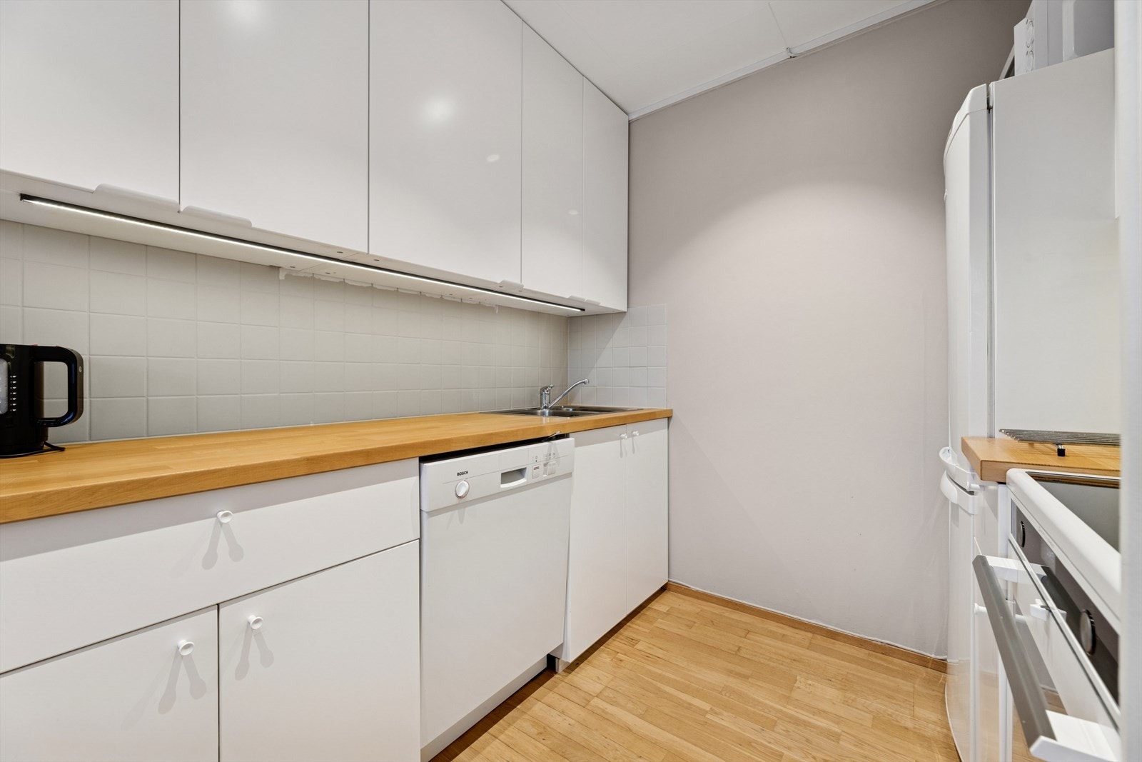 Kjøkkenet har en innredning med glatte fronter og laminat benkeplate. Galleribilde