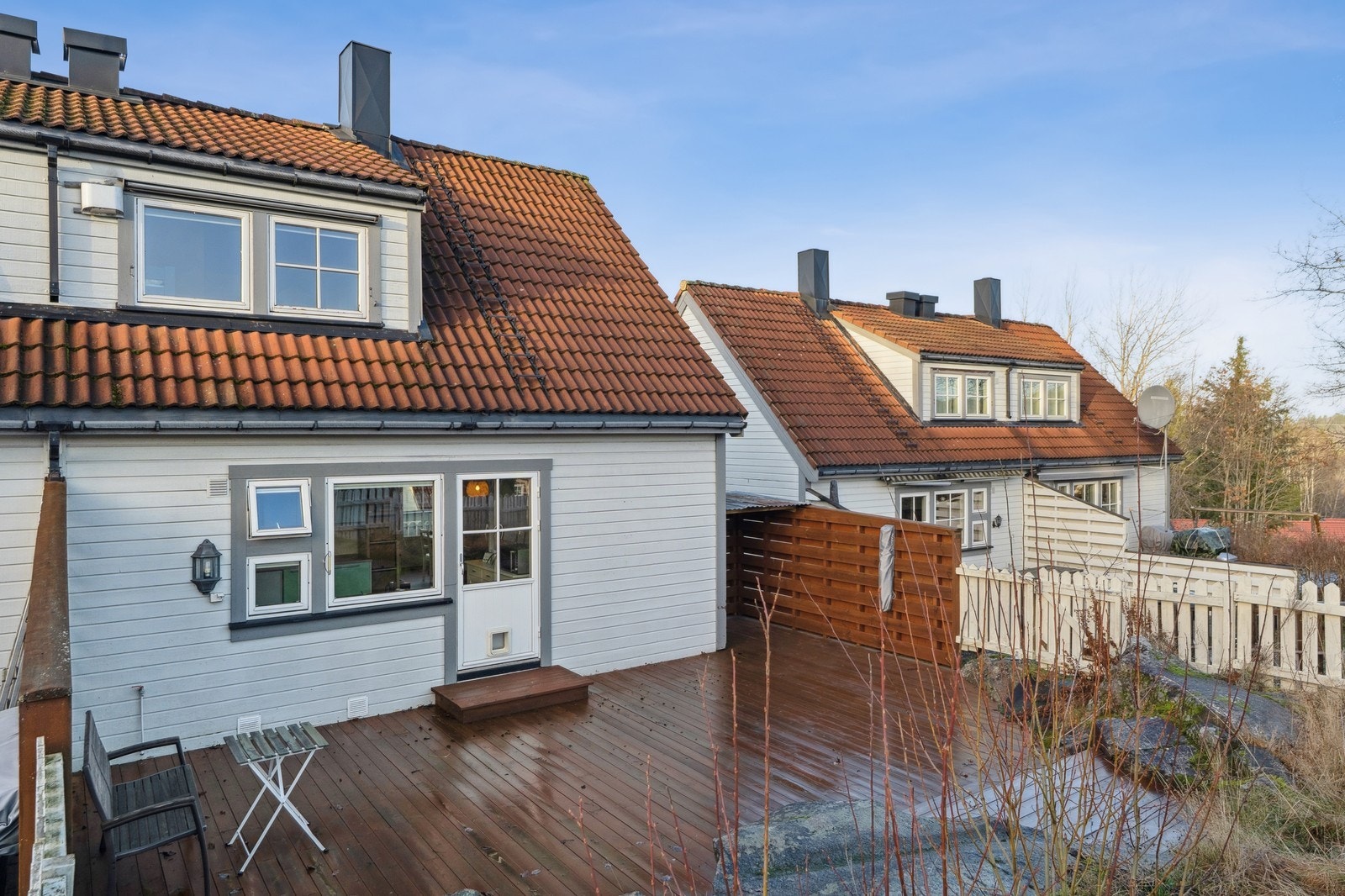 Flott og skjermet terrasseplatting og hage på baksiden av huset Galleribilde