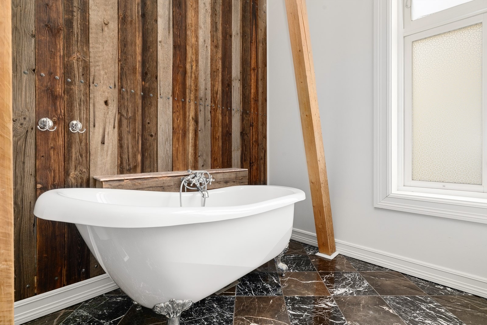 Badet er innredet med toalett, badekar og servantinnredning med skuffer, skap og speil med lys. Det er avtrekksvifte i vegg. Galleribilde