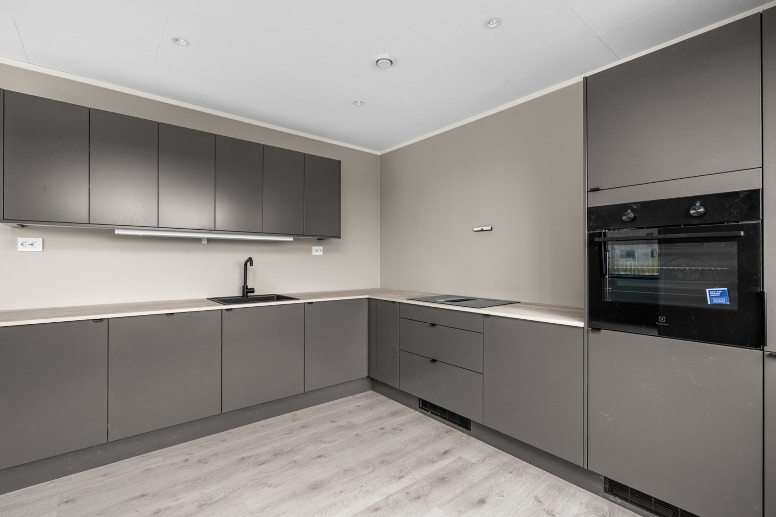 Kjøkkenet har innredning med glatte fronter. Benkeplaten er av laminat. Galleribilde