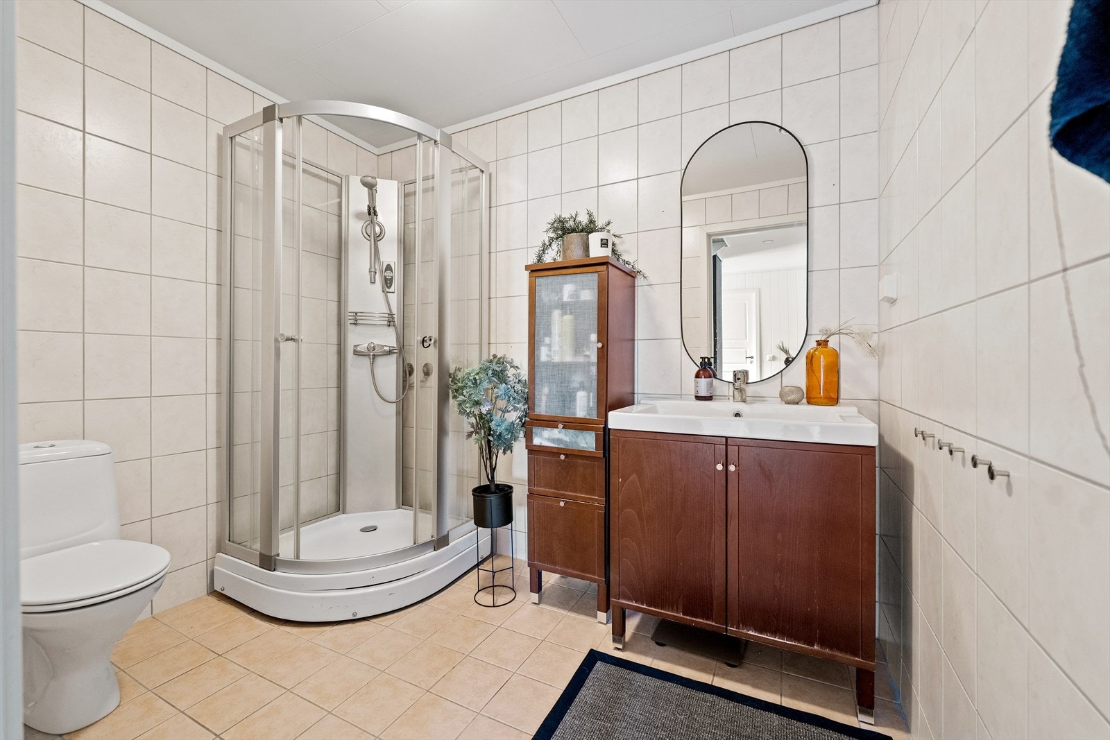 Bad med gulvvarme og flislagte vegger og gulv. Innredet med servant over baderomsmøbel, klosett, dusjkabinett, speil og belysning. Galleribilde