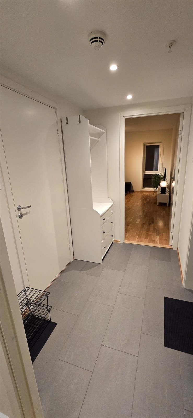 Flislagt entré med plass til oppheng av sko og yttertøy. Galleribilde