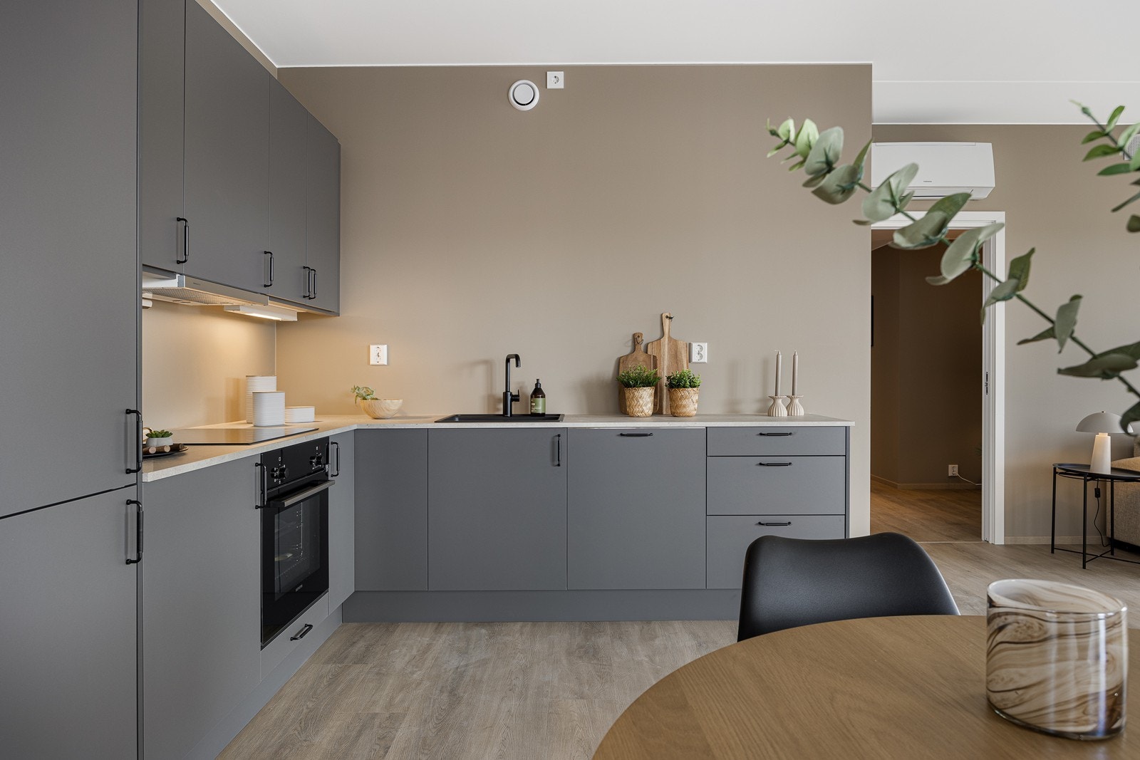 Innredningen er i en pen gråfarge med sorte grep. Benkeplaten er i en lys farge med servant og armatur i sort Galleribilde