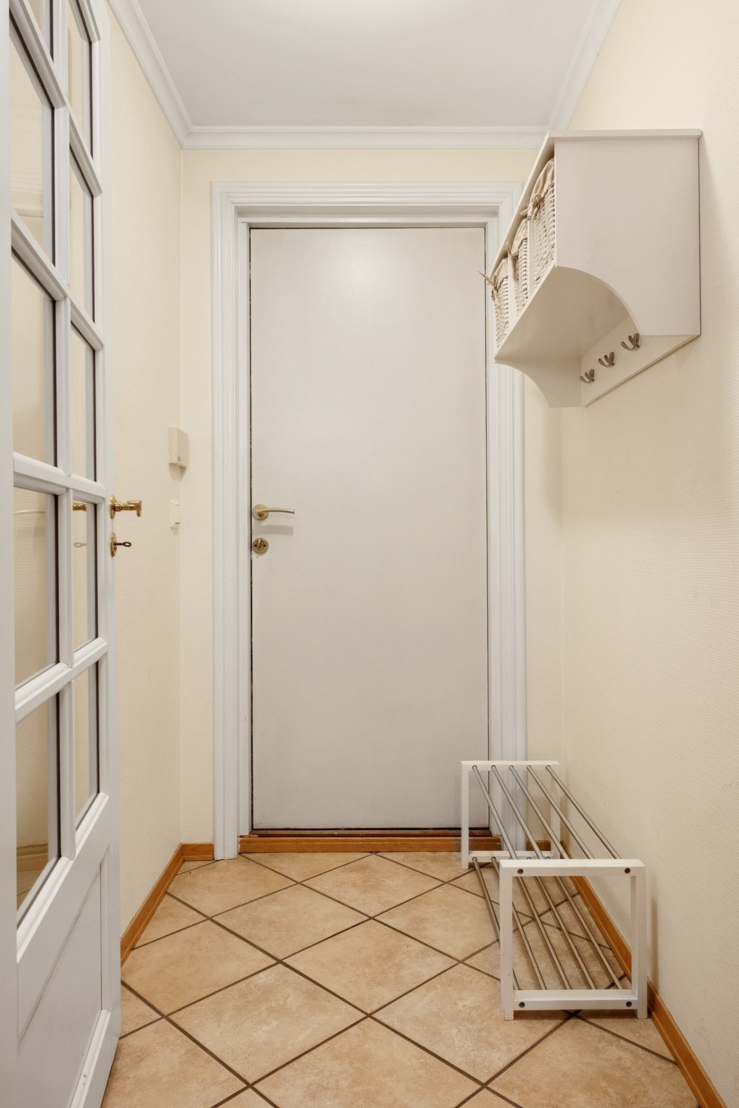 Vindfang til den nordre fløyen har flislagt gulv og hylle med knagger. Galleribilde