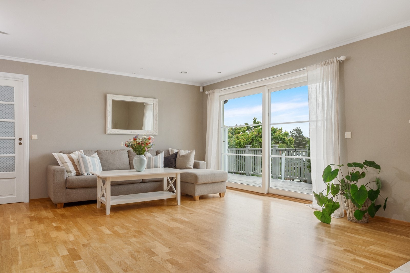 Fra dagens sofahjørne fører en stor skyvedør ut til vestsiden av veranda - en fin forlengelse av stuen på sommerdager. Galleribilde