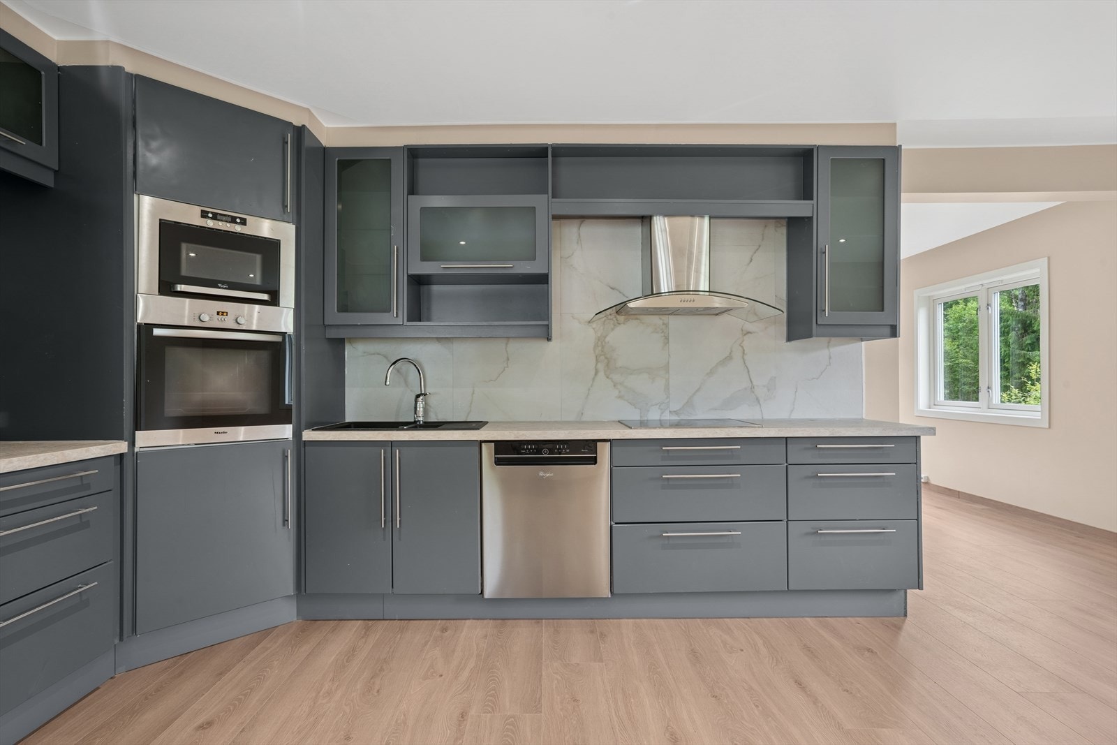 Lekker kjøkkeninnredning med slette malte fronter og integrerte hvitevarer. Galleribilde