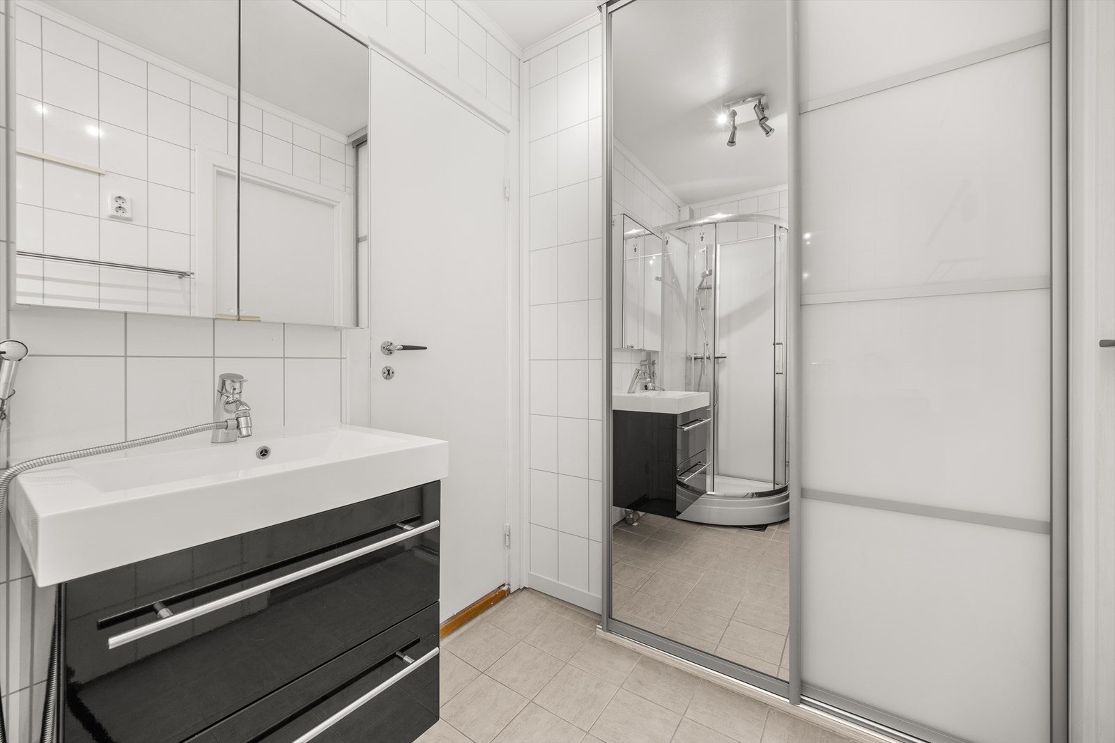 Badet er utstyrt med servant med underskap, speilskap, dusjkabinett, samt opplegg for vaskemaskin Galleribilde