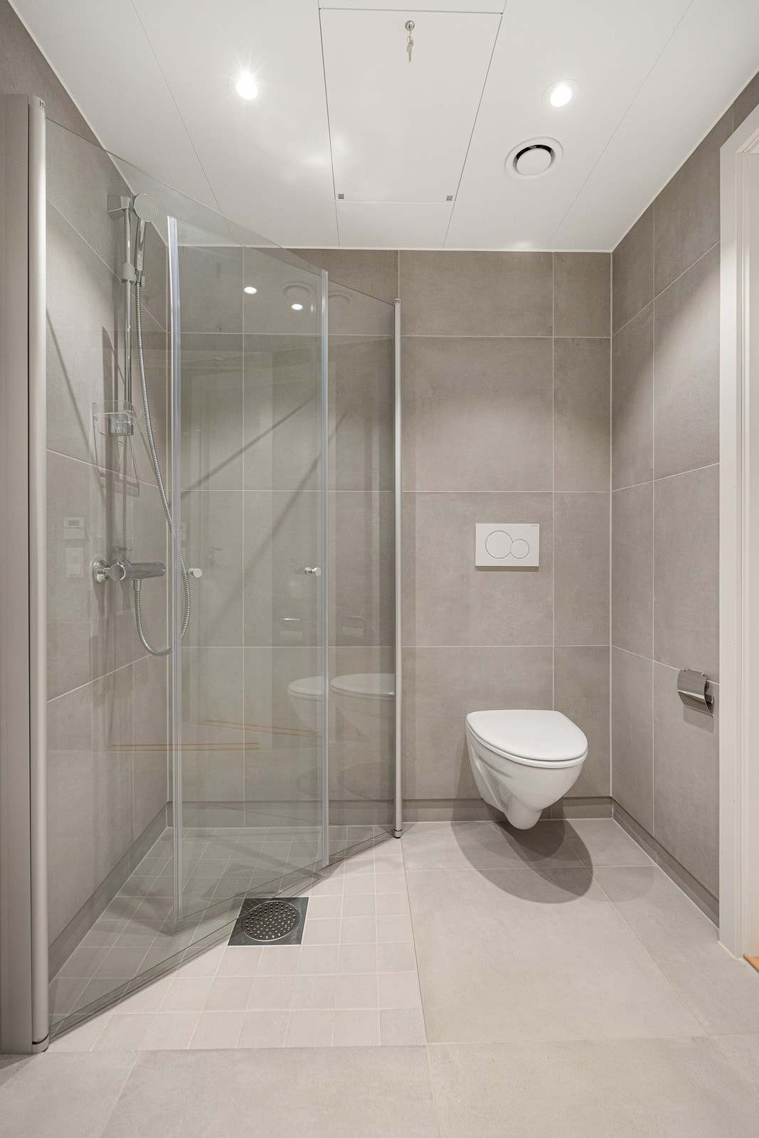 Det er vegghengt toalett og innfellbare dusjdører i herdet glass. Galleribilde